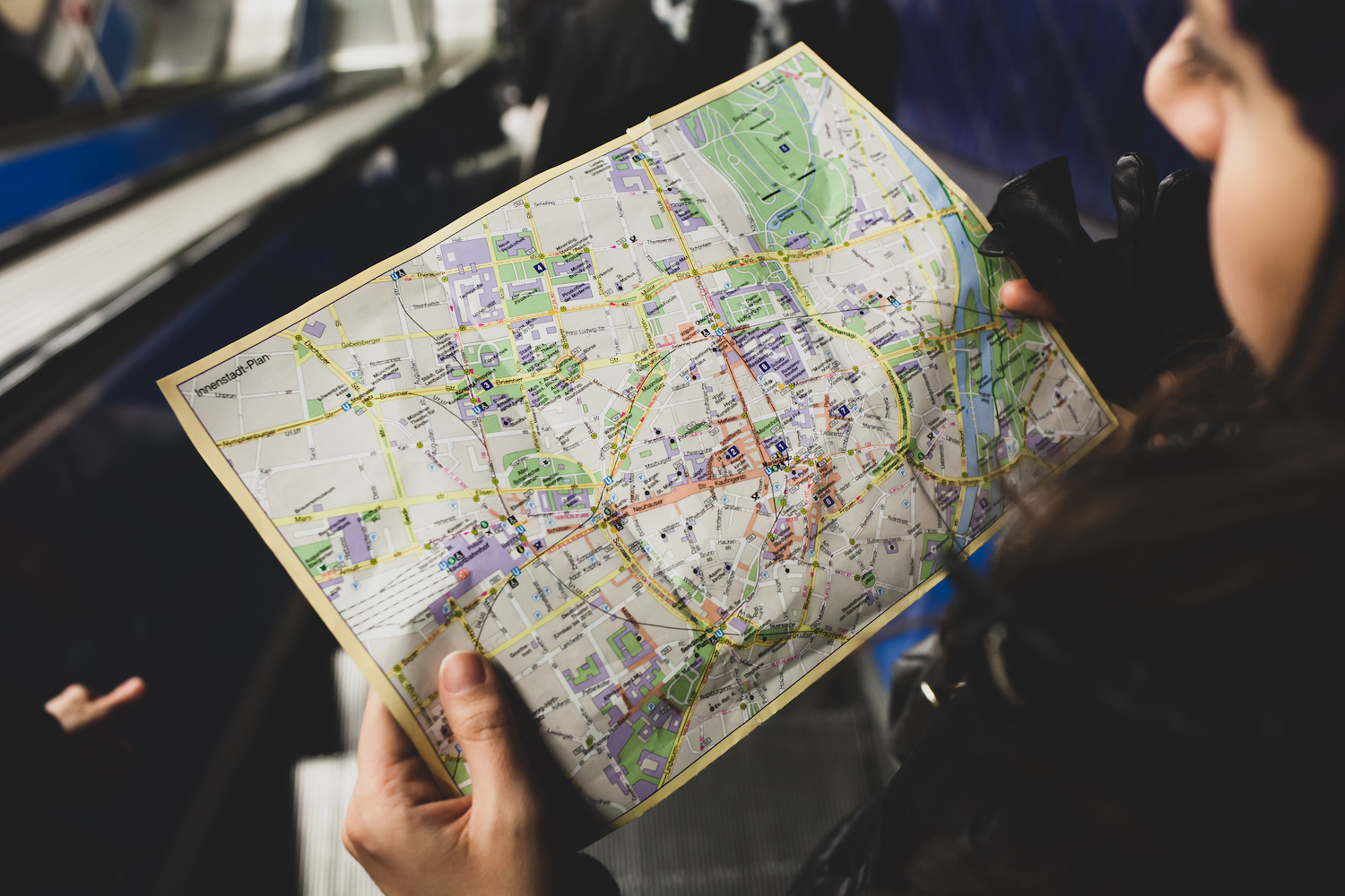 Young woman tourist studying the map of the city of Monaco of Bavaria in the subway.
