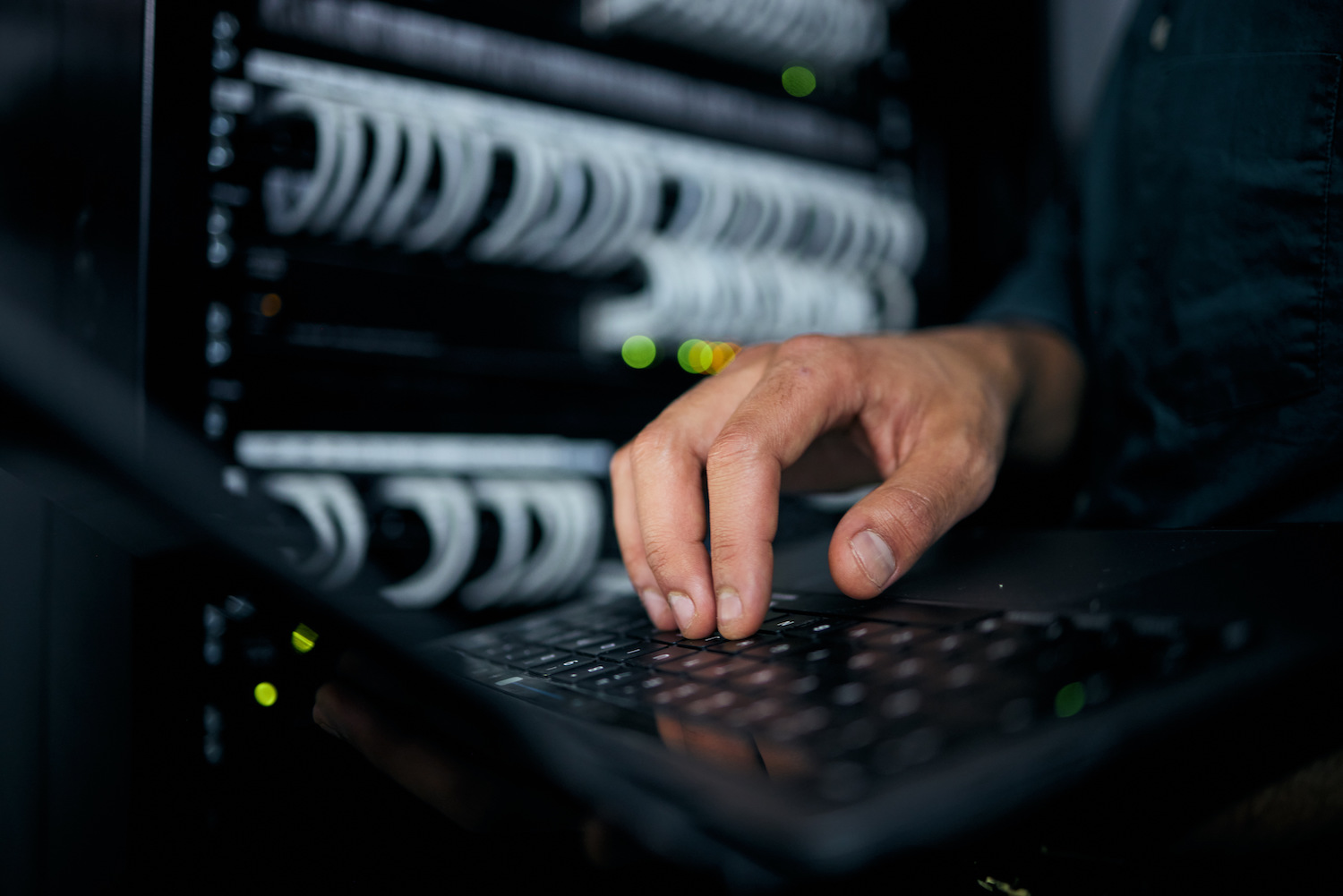 Hands, laptop and typing in server room, man and inspection with coding, analysis and night for pro